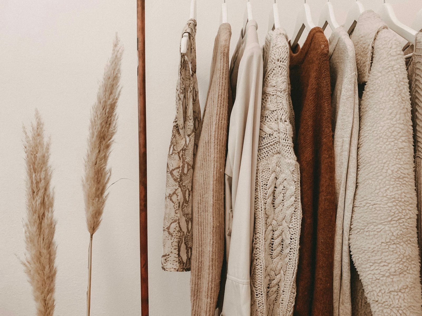 Portant de vêtements aux tons naturels dans l'atelier