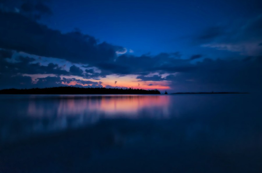 Lac au crépuscule, ciel orangé à l'horizon